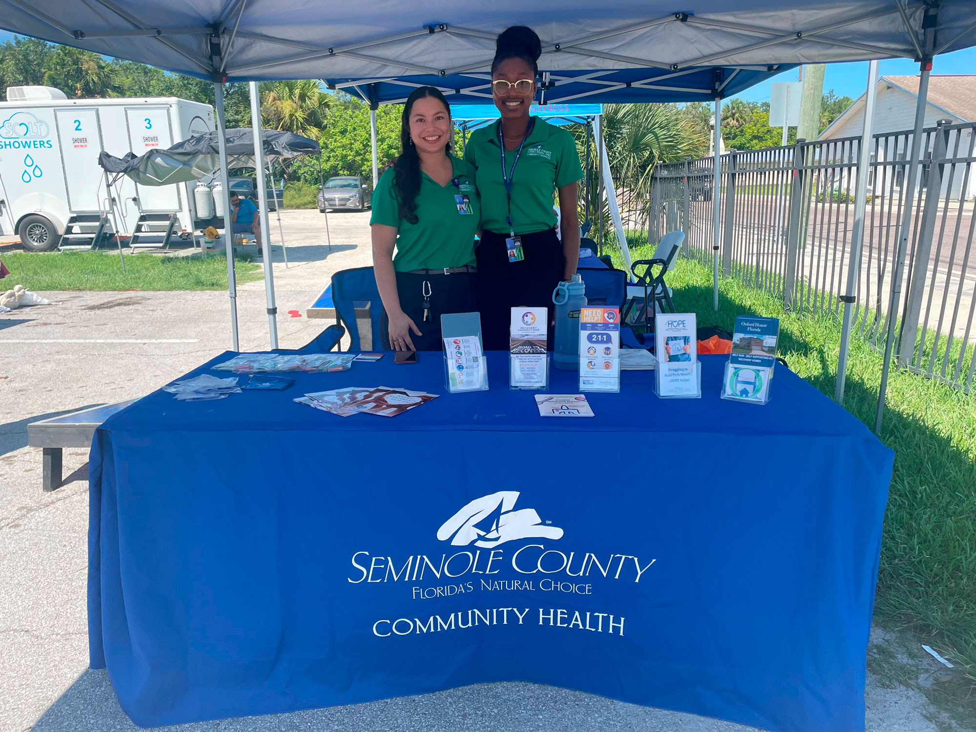 community health employees staff a tent at a community health event